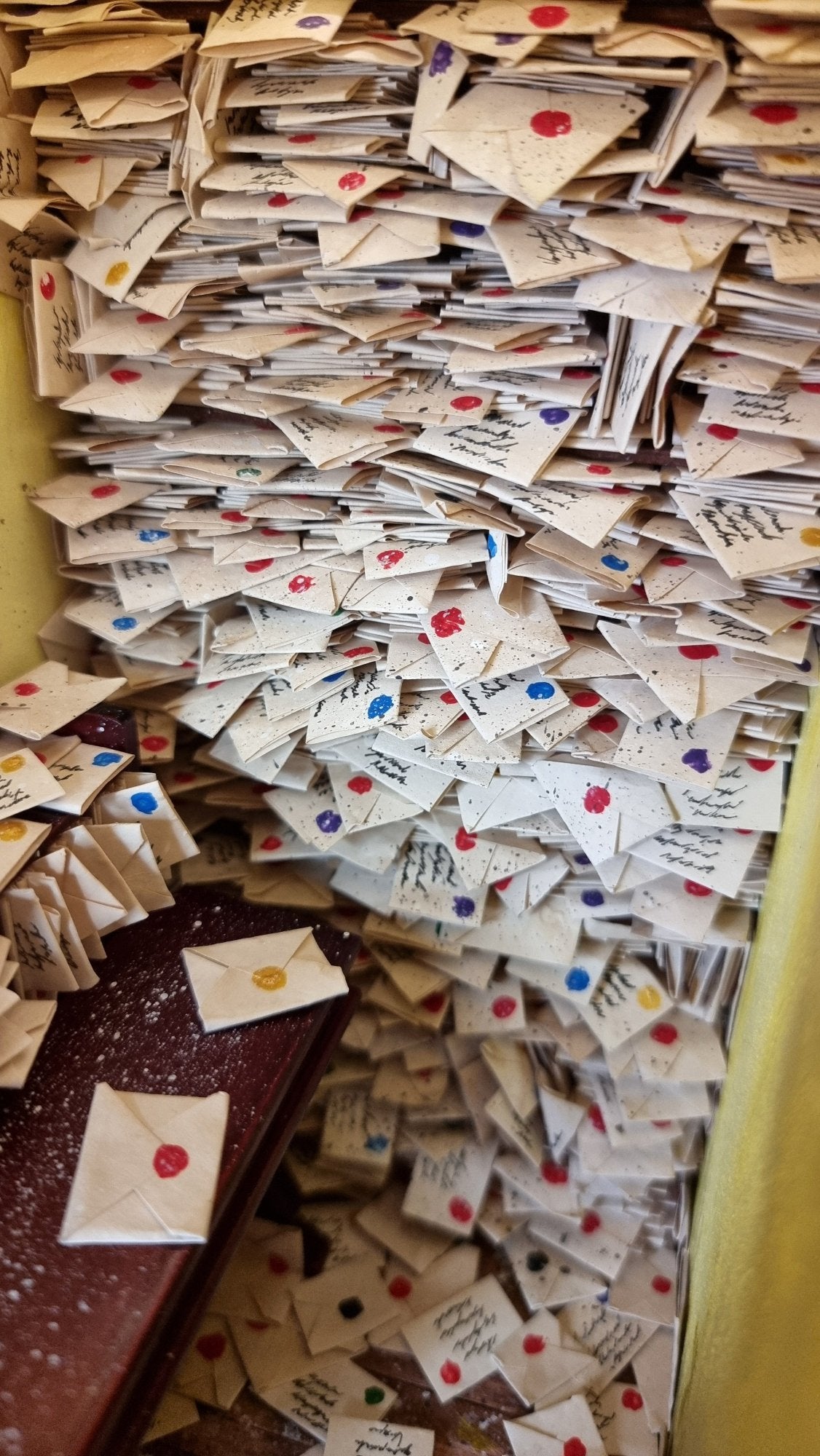 Hundreds of 1:12 scale letters are crammed into shelves above a desk crammed with more letters