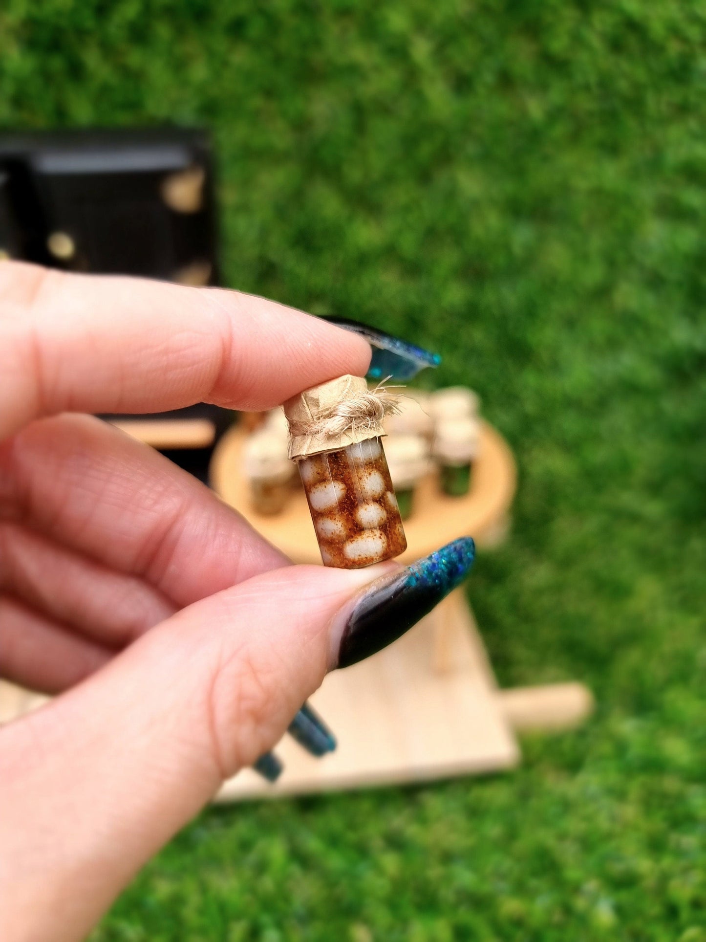 Single 1:12 scale miniature preserve jar with paper lid. Jar contain pickled eggs. Jar is held between thumb and finger