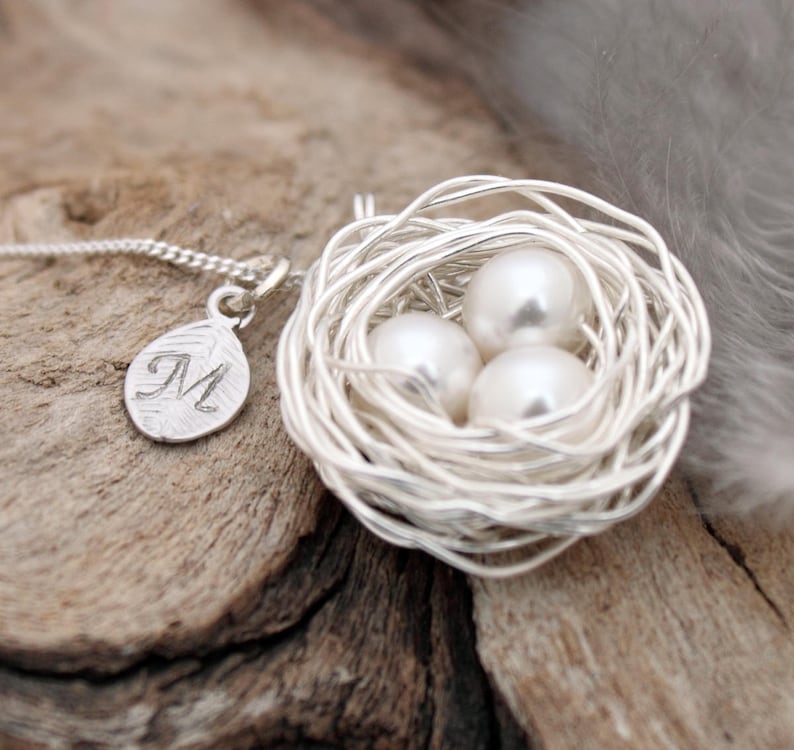 Silver coloured woven wire and ivory pearl eggs necklace with silver coloured leaf charm with stamped calligraphic M initial