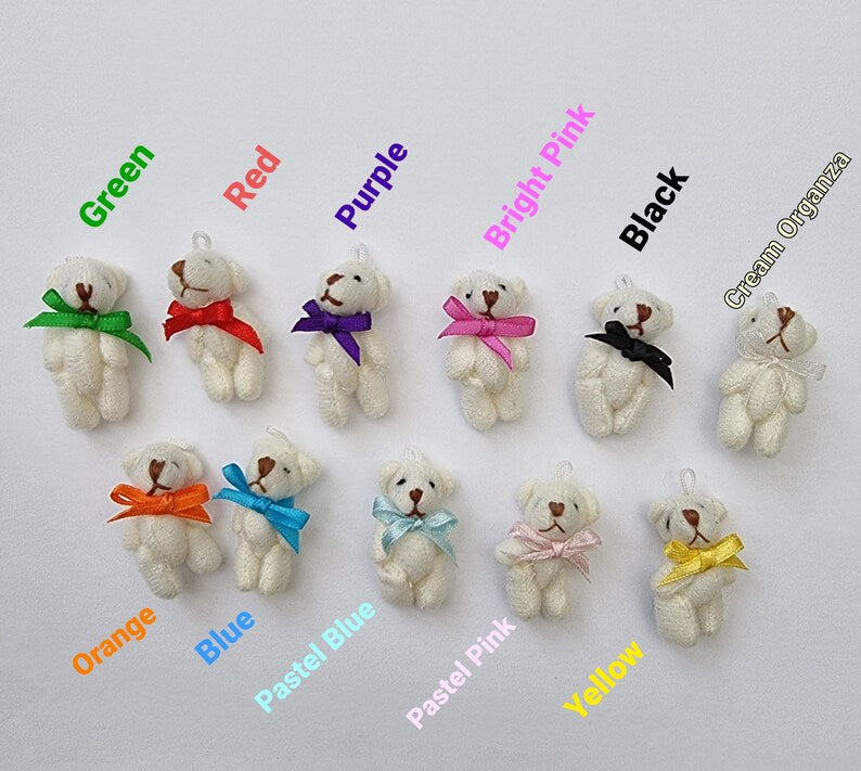 11 cream bears with 11 different coloured bow ties are displayed on a white background with a text description of the colour displayed beside each bear