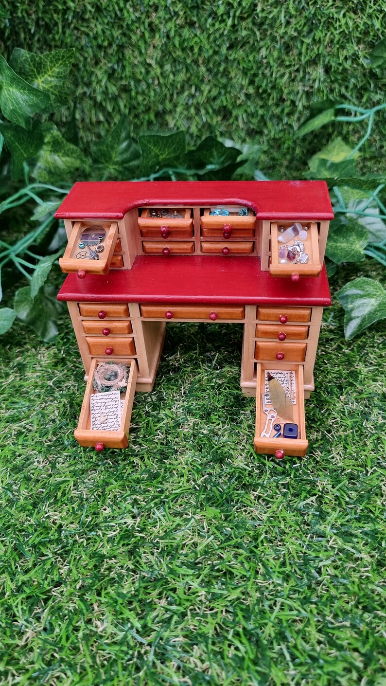 1:12 scale desk with 21 drawers has  6 open drawers. Each drawer is filled with different items, including parchments, nest, quill, inkwell, gemstones, nest, trinkets and curios